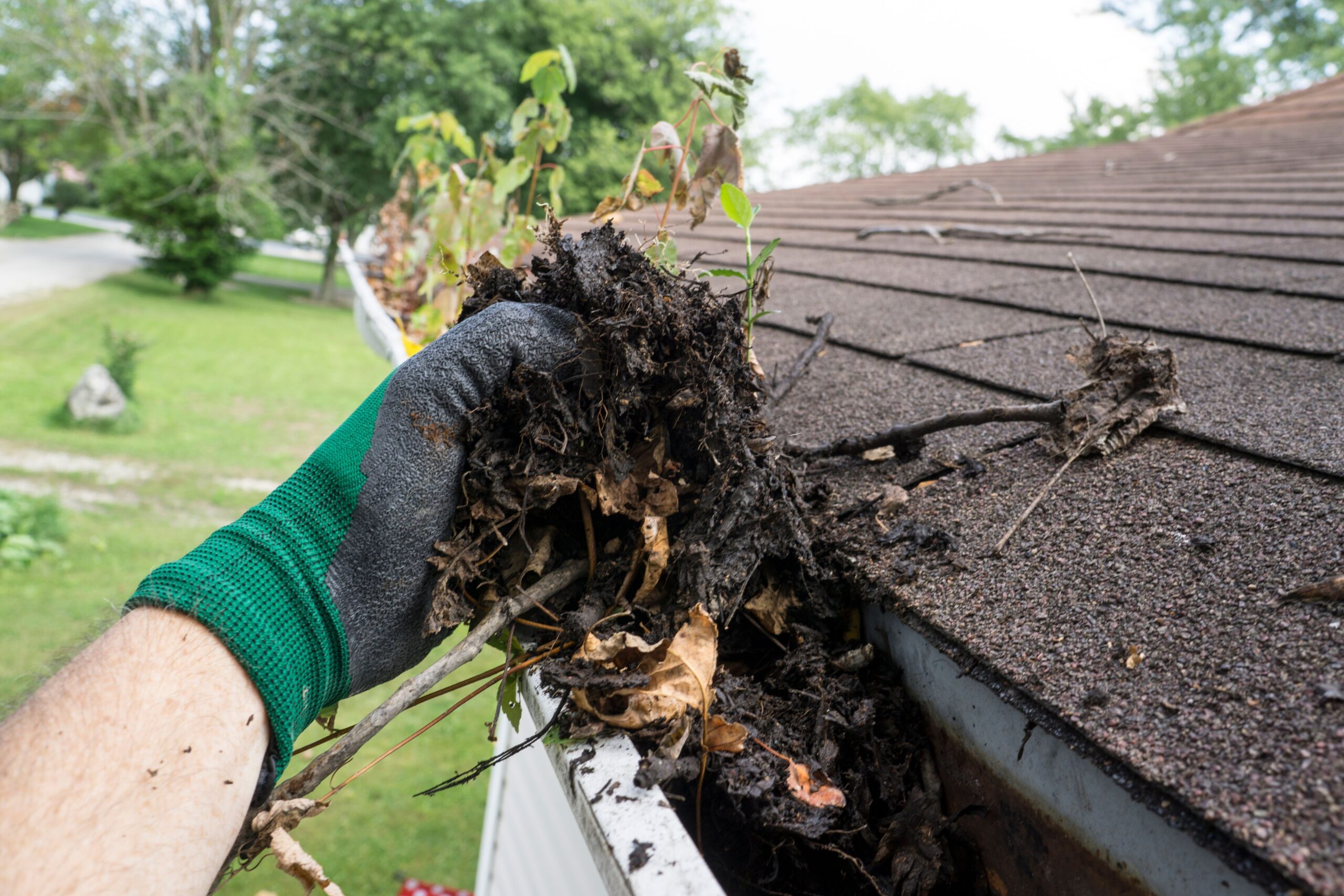 A person cleaning the gutter.