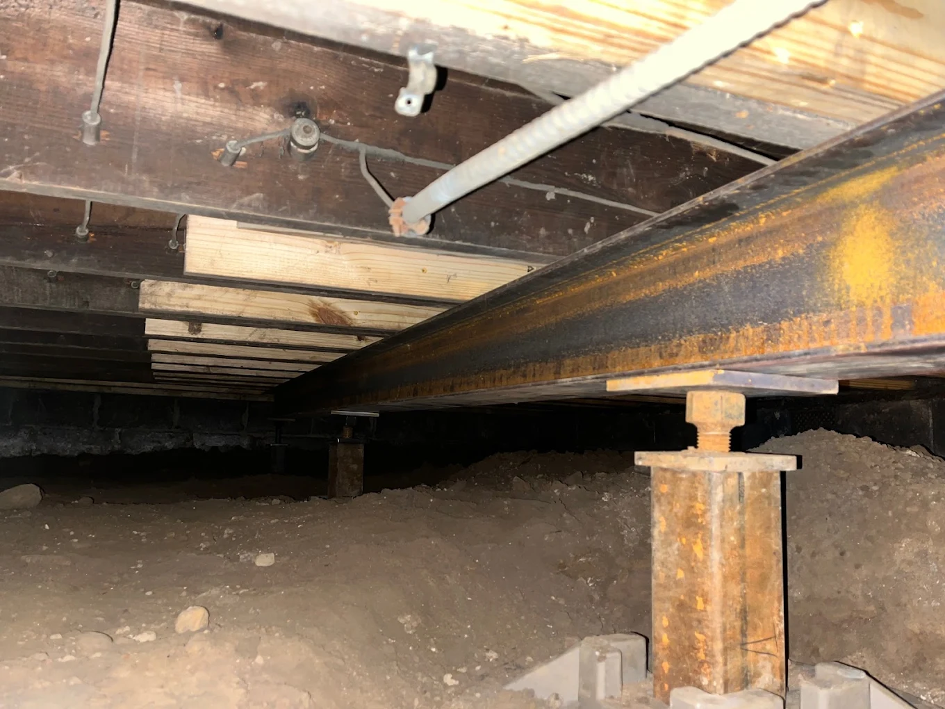 Steel support beam running across crawl space